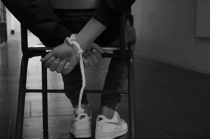 person tied up on a chair